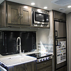 Kitchen with flip-up solid surface countertop extension, stainless steel sink and residential faucet.  Shown in Driftwood2
